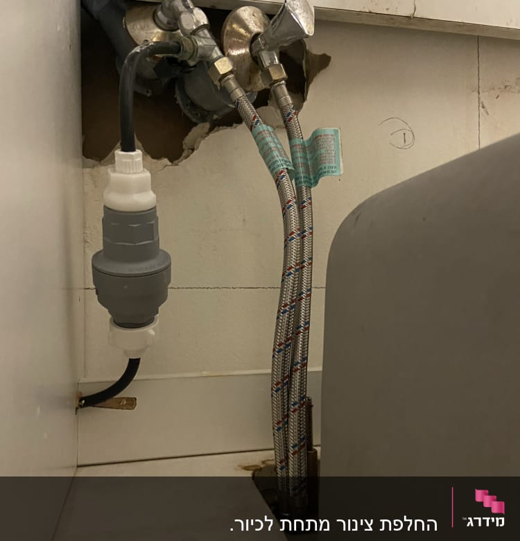 צינורות מים מחוברים לברזים בקיר עם חיבורים מתכתיים